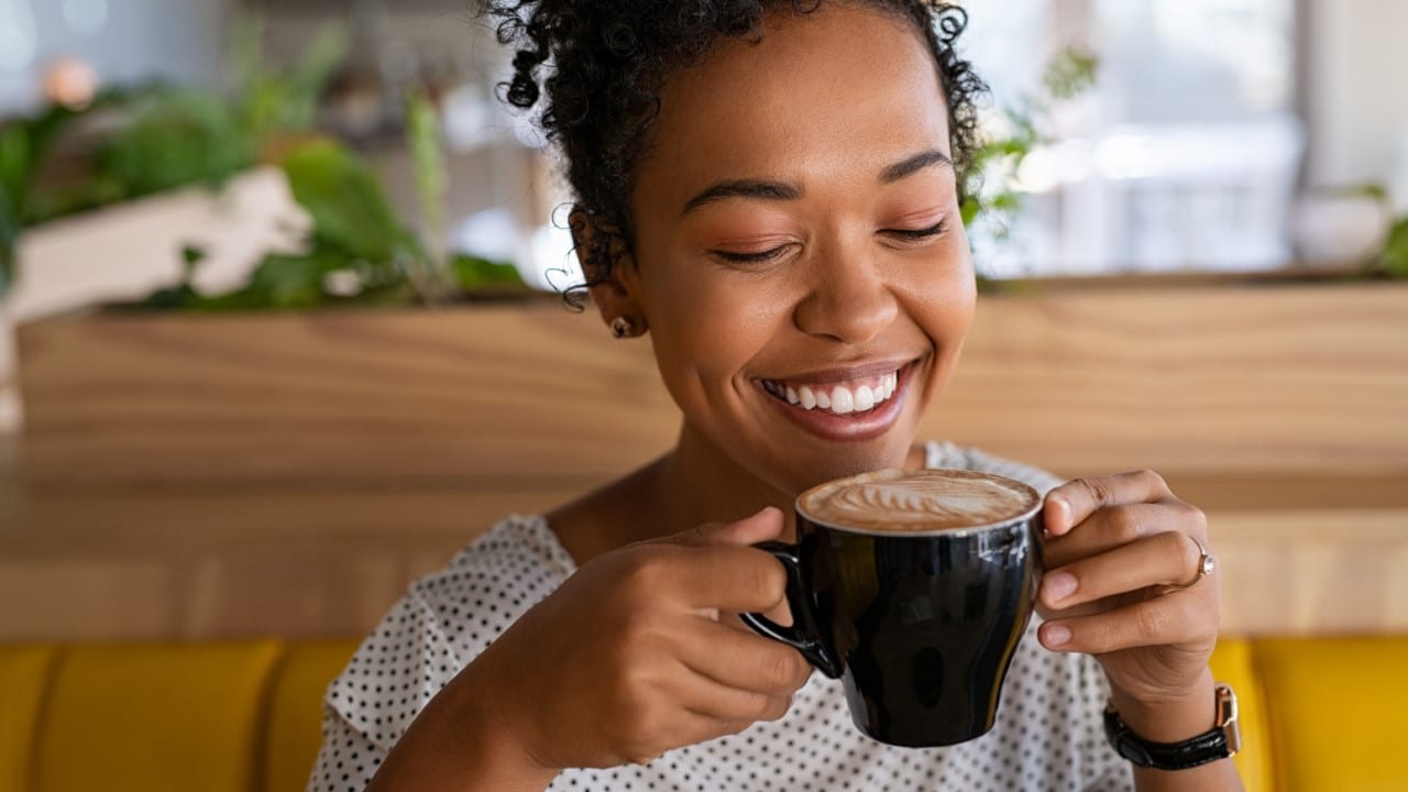 Woman smelling coffee.